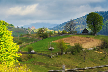 Spring morning rural landscape with cute farm outside the fence in the Mizhhiria, Carpathian...