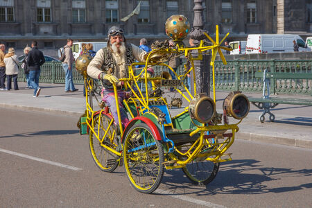 Paris, France - May 3, 2014: Unusual old man with a mustache on creative bike on a bridge over the...