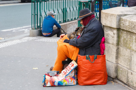 Paris, France - December 20, 2014: Clochard, homeless with dog in winter on the Paris waterfrontのeditorial素材