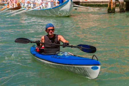 Venice, Veneto, Italy - May 24, 2015: Man oarsmen, in an blue boat race along the Cannaregio Canal in the Venice Vogalonga regatta. More than 1,500 boats take part in the annual historic regatta. Selective focus on the foregroundのeditorial素材