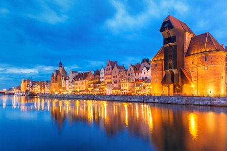 Old harbour crane and city gate Zuraw in old town of Gdansk, Dlugie Pobrzeze and Motlawa River at night, Polandの写真素材