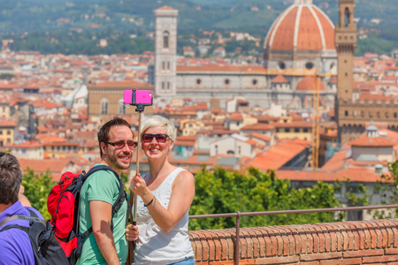 Florence, Tuscany, Italy - May 17, 2015: Tourists young happy couple making selfie against the backdrop of the Duomo Santa Maria Del Fiore at sunny day.のeditorial素材