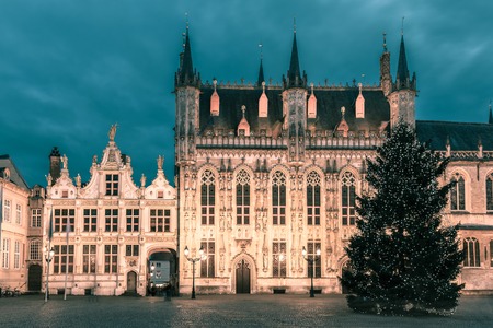 Scenic cityscape with the picturesque night medieval Christmas Burg Square in Bruges, Belgium. Toning in cool tonesの写真素材