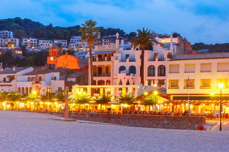 Night beach and promenade with cafes and restaurants in Tossa de Mar on the Costa Brava, Catalunya, Spainの写真素材