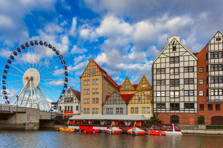 Ferris wheel with water reflection at Trade fair St Dominic in Old Town of Gdansk in the morning,...