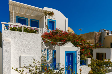 Picturesque view of white and blue houses and windmill in Oia or Ia, island Santorini, Greeceの写真素材