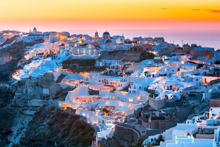 Picturesque view, Old Town of Oia or Ia on the island Santorini, white houses and church with blue domes at sunset, Greeceの写真素材