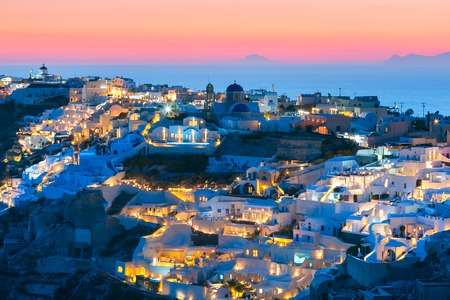 Picturesque view, Old Town of Oia or Ia on the island Santorini, white houses and church with blue domes at sunset, Greeceの写真素材