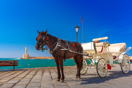 Horse carriage and Lighthouse in old harbour of Chania on a summer sunny day, Crete, Greeceの写真素材