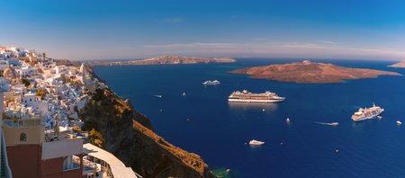 Panorama of Fira, modern capital of the Greek Aegean island, Santorini, with orthodox church, cruise ships, caldera and volcano, Greeceの写真素材
