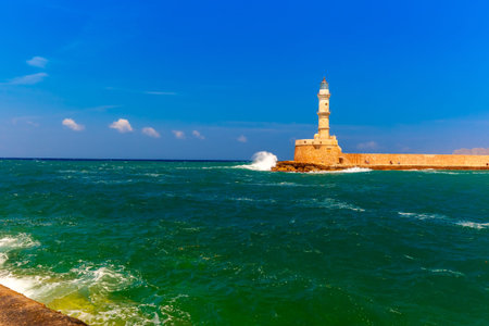 Waves beat against the lighthouse in old harbour of Chania in the summer sunny day, Crete, Greeceの写真素材