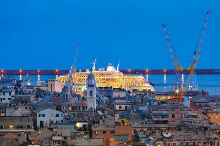 Aerial view of old town and port with cranes and ship at night, Genoa, Italy.の写真素材