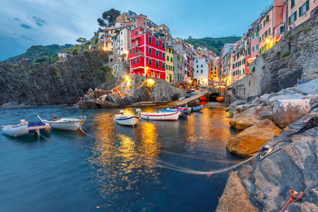 Riomaggiore fishing village during evening twilight blue hour, seascape in Five lands, Cinque Terre National Park, Liguria, Italy.の写真素材