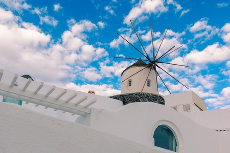 Picturesque white house and windmill in Oia or Ia on the island Santorini, Greeceの写真素材