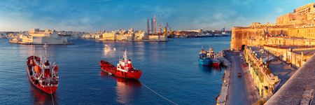 Panoramic skyline view of ancient defences of Valletta and the Grand Harbor with ships and Three cities, three fortified cities of Birgu, Senglea and Cospicua, at dawn. Malta.の写真素材