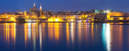 Valletta Skyline at night with church of Our Lady of Mount Carmel and St. Pauls Anglican Pro-Cathedral, Valletta, Capital city of Malta. Panoramic view from Sliema.の写真素材