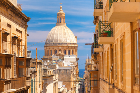 The traditional Maltese colorful wooden balconies and Our Lady of Mount Carmel in Valletta, Maltaの写真素材