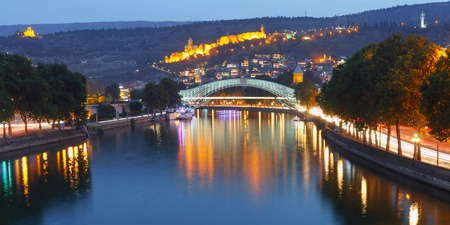 Panorama of night Old Town with Narikala Fortress and illuminated Bridge of Peace across Kura river, Tbilisi, Georgiaの写真素材