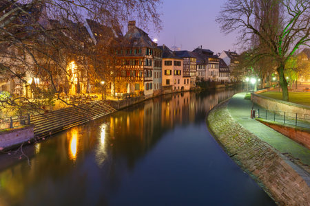 Traditional Alsatian half-timbered houses and canal in Petite France during twilight blue hour,...
