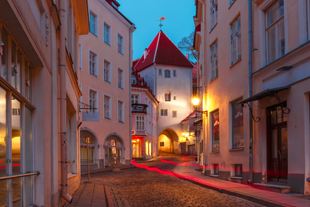 Beautiful illuminated medieval street in Old Town of Tallinn during evening blue hour, Estoniaの写真素材