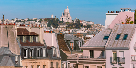 Sacre-Coeur Basilica above of the city skyline and parisian roofs at the sunny summer morning, Paris, Franceの写真素材