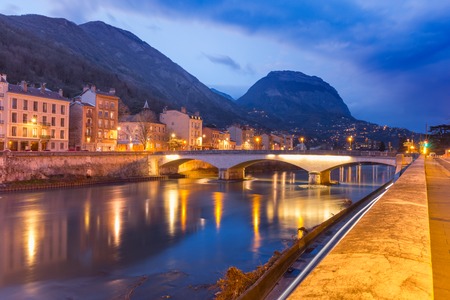 Scenic view of the banks of the Isere river and bridge, Collegiate Church of Saint-Andre with French Alps on the background, Grenoble, Franceの写真素材