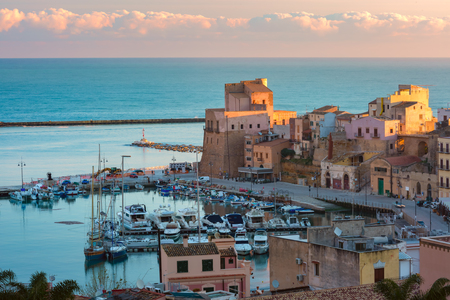 Beautiful aerial view of medieval fortress in Cala Marina, harbor in coastal city Castellammare del Golfo at sunset, Sicily, Italyの写真素材