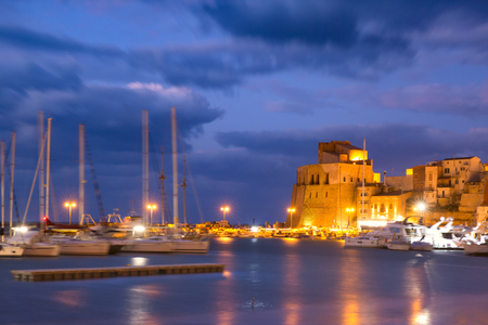 Medieval fortress in Cala Marina, harbor in coastal city Castellammare del Golfo at night, Sicily, Italyの写真素材