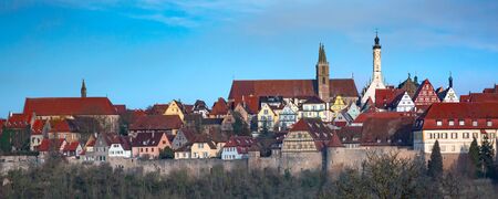 Aerial panoramic view of town wall, quaint colorful facades and roofs of medieval old town of Rothenburg ob der Tauber, Bavaria, Germanyの写真素材