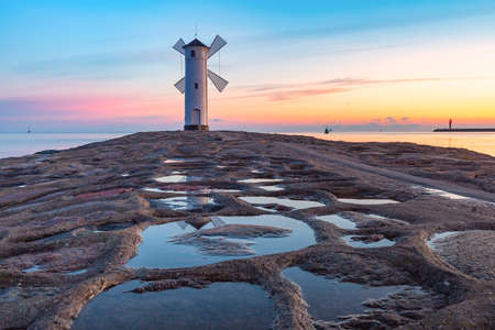 Baltic sea and Stawa Mlyny, navigation beacon in shape of windmill at sunset, official symbol of Swinoujscie, Polandの写真素材