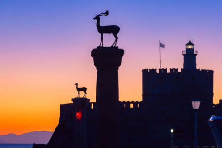 Statues of deer at Mandraki harbor entrance at sunrise, Rhodes Greeceの写真素材