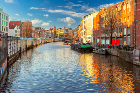 Sunny Amsterdam canal Singel and flower market Bloemenmarkt at golden hour, Holland, Netherlands.の写真素材