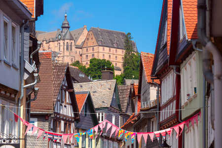 Traditional timber-framed houses line the cobblestone street leading to Marburg Castle, Germanyの写真素材