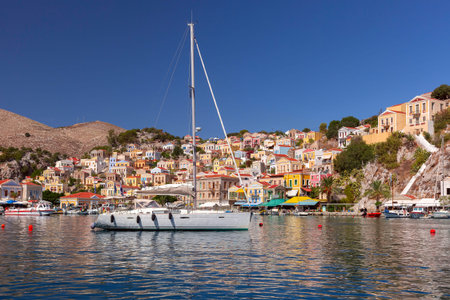 Serene harbor view with traditional fishing boat on Symi Island, Greece