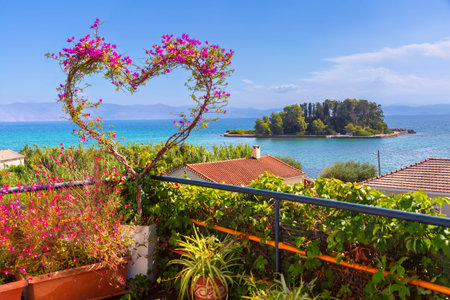 Scenic view of a heart-shaped flower arrangement framing the sea and a small island in Corfu, Greeceの写真素材