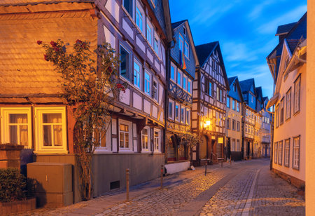 A quiet street in Marburg, Germany, showcasing well-preserved half-timbered houses at duskの写真素材