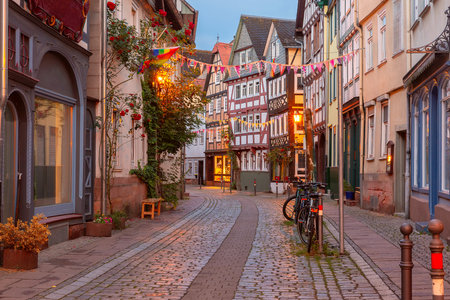 Colorful old town street in Marburg, Germany, half-timbered houses and festive decorations at duskの写真素材