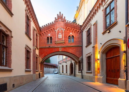 View of a historical archway on Kanonicza Street in Krakow, Poland, with brick facade and illuminated windowsの写真素材