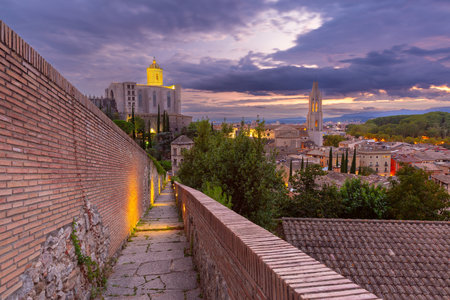 A view of Girona Cathedral and the Church of Sant Feliu from the medieval city walls in Girona, Spain, at dusk.の写真素材