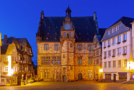 Historic town hall on the illuminated market square in Marburg Germany with surrounding buildingsの写真素材