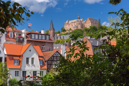 Landgrafenschloss castle on hill above traditional fachwerk houses in Marburg Germany on a sunny...