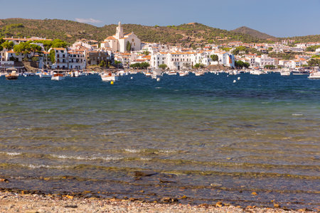 Shallow coastal water and boats facing Cadaques village in Spainの写真素材