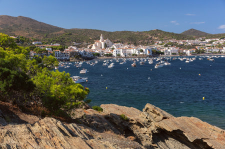 Shallow coastal water and boats facing Cadaques village in Spainの写真素材