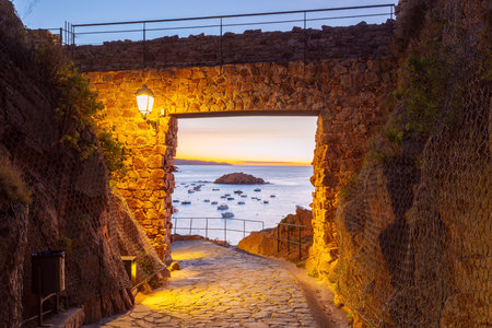 Stone gate entrance to Vila Vella fortress at sunset in Tossa de Mar, Spainの写真素材