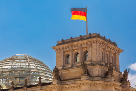 Reichstag building in Berlin Germany with glass dome and German flags on a sunny dayの写真素材