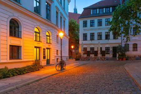 Quiet cobbled street in Nikolai Quarter at dawn in Berlin Germany with soft lighting and historic...