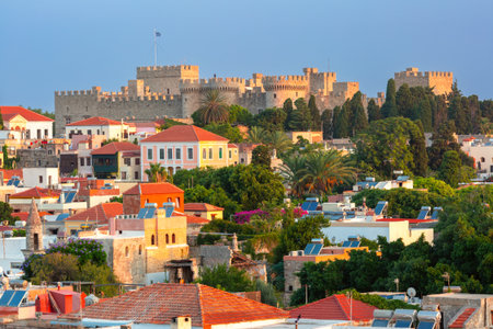 Sunrise view of the Grand Master Fortress in Rhodes, Greece, with colorful houses and greenery in the old town of Rhodes city, Greeceの写真素材