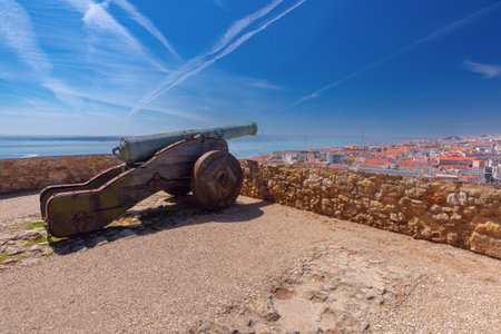 Old cannon facing Lisbon rooftops and river from historic fortress in Lisbon, Portugalの写真素材