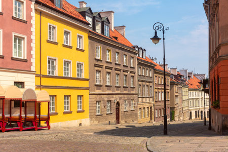 Row of colorful historic buildings along a cobblestone street in Old Town, Warsaw, Poland, on a sunny dayの写真素材