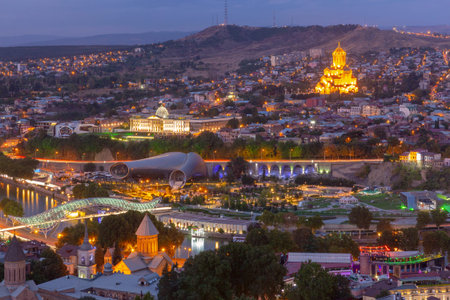 Night view of central Tbilisi, Georgia with illuminated landmarks including Holy Trinity Cathedral...